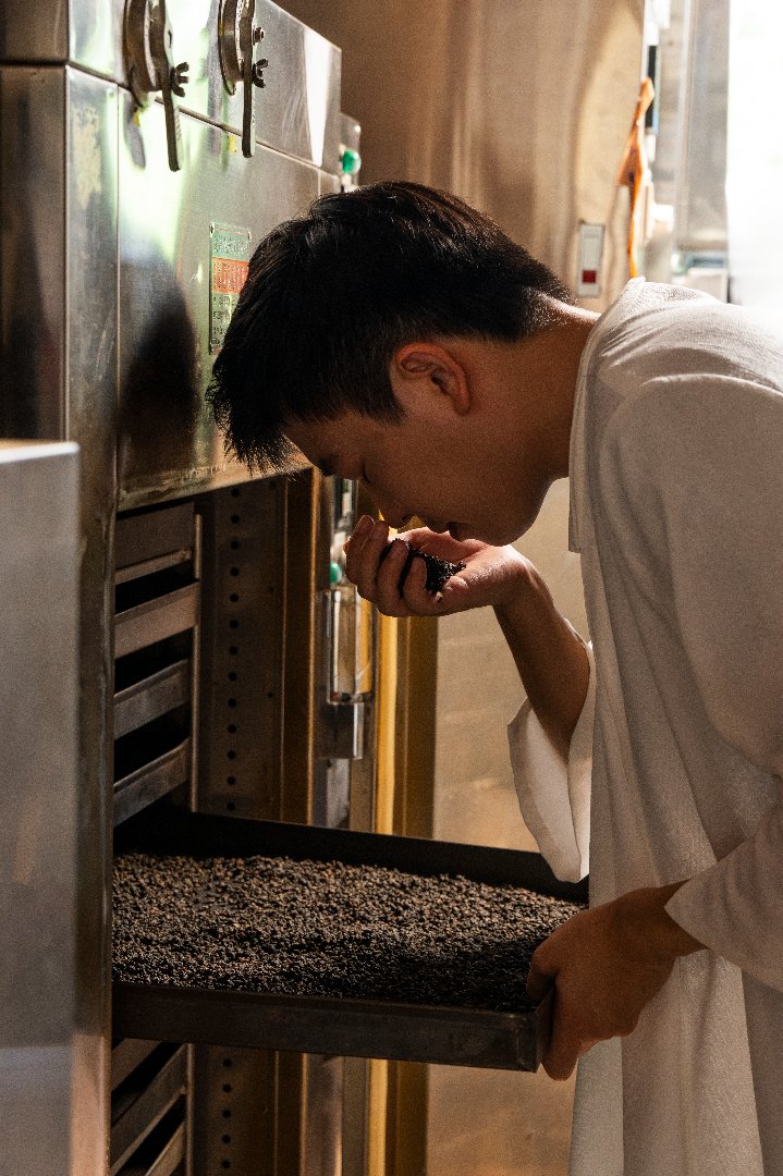 簡睿宏仔細評鑑細聞茶葉的香氣.