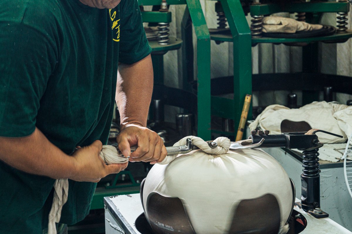 A man working with the canvas wrapping-rolling machine.