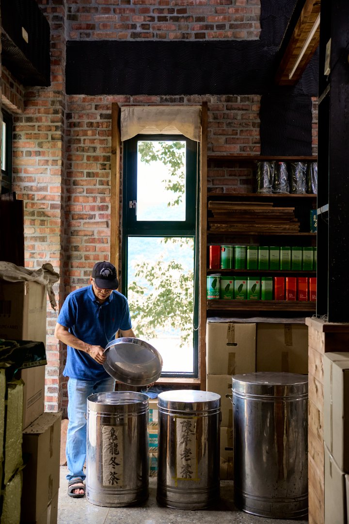 A man opening a large tea barrel.