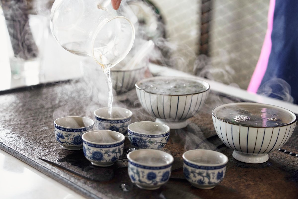 茶桌上的茶杯和茶碗冒著蒸氣氤氣裊裊.