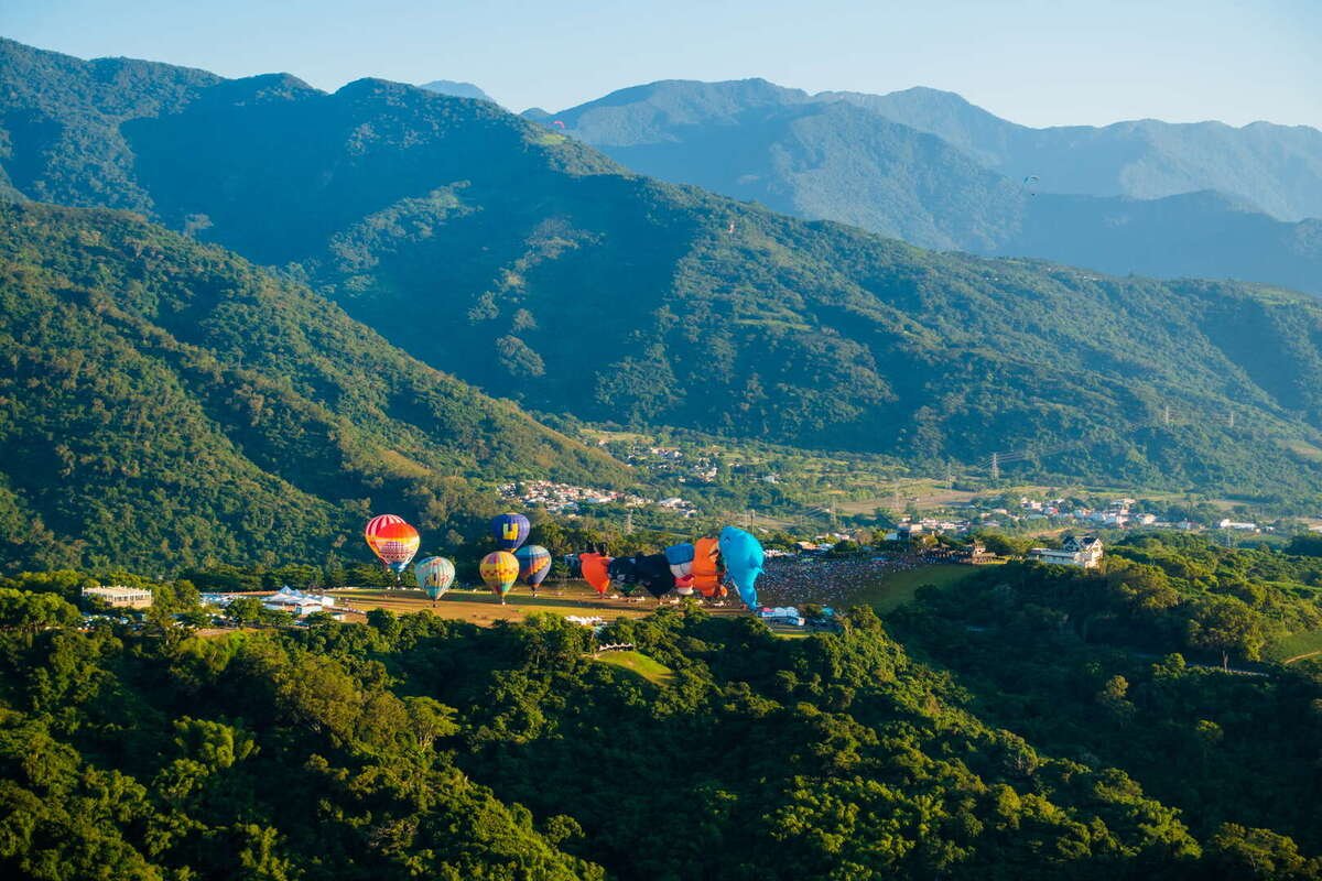A row of hot-air balloons lining up in the valley.