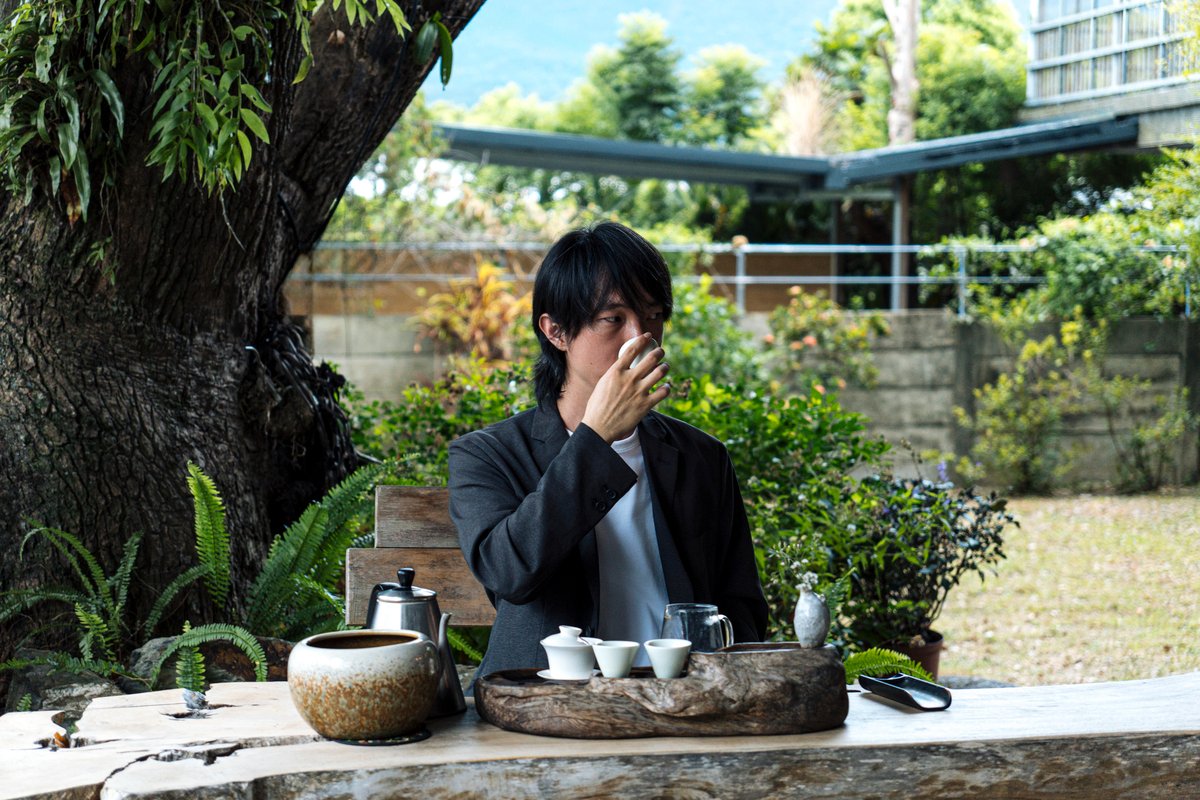 張一鳴在大樹下的古老茶桌邊品茗.