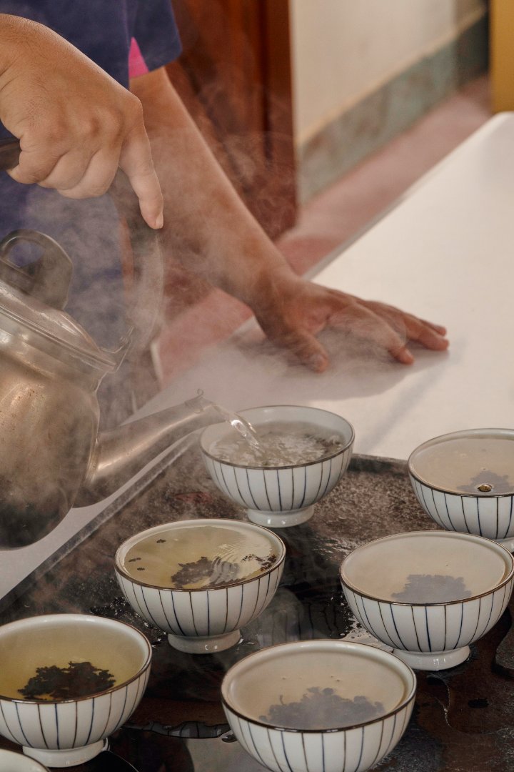 滾燙的熱水注入茶碗中冒著蒸氣.