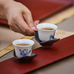 A tiny tea cup holding ruby red Red Oolong tea.