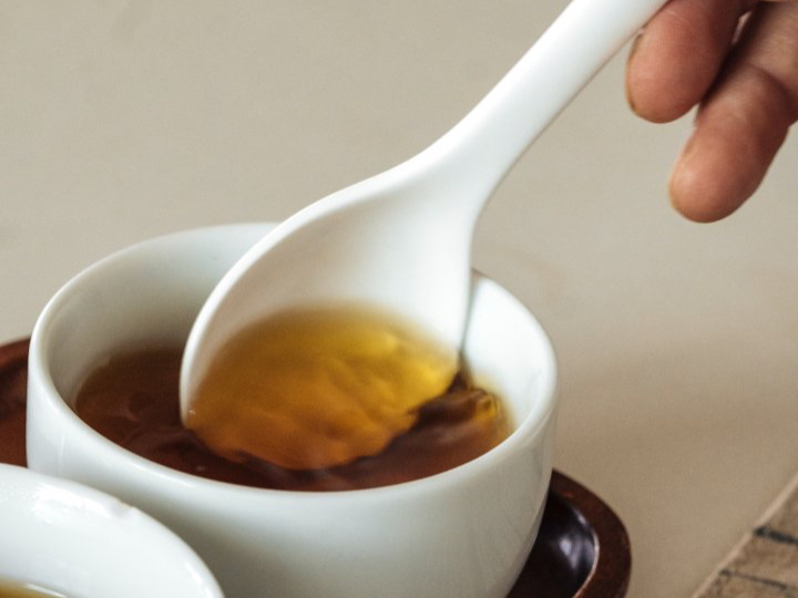 A tea spoon gently stirring Red Oolong tea.