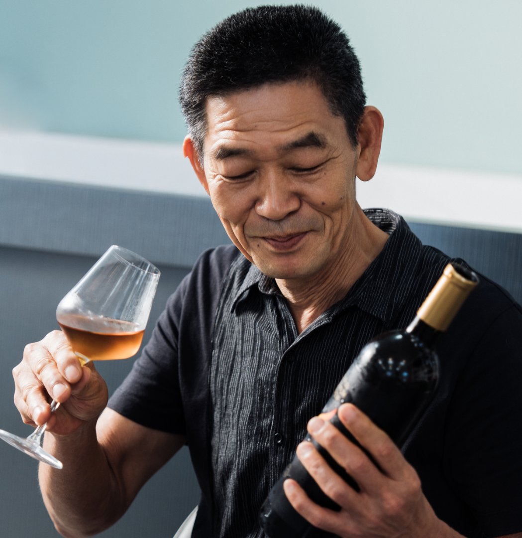 Yunfang Tea Garden's owner smiling at his Premium Brew collection with pride.